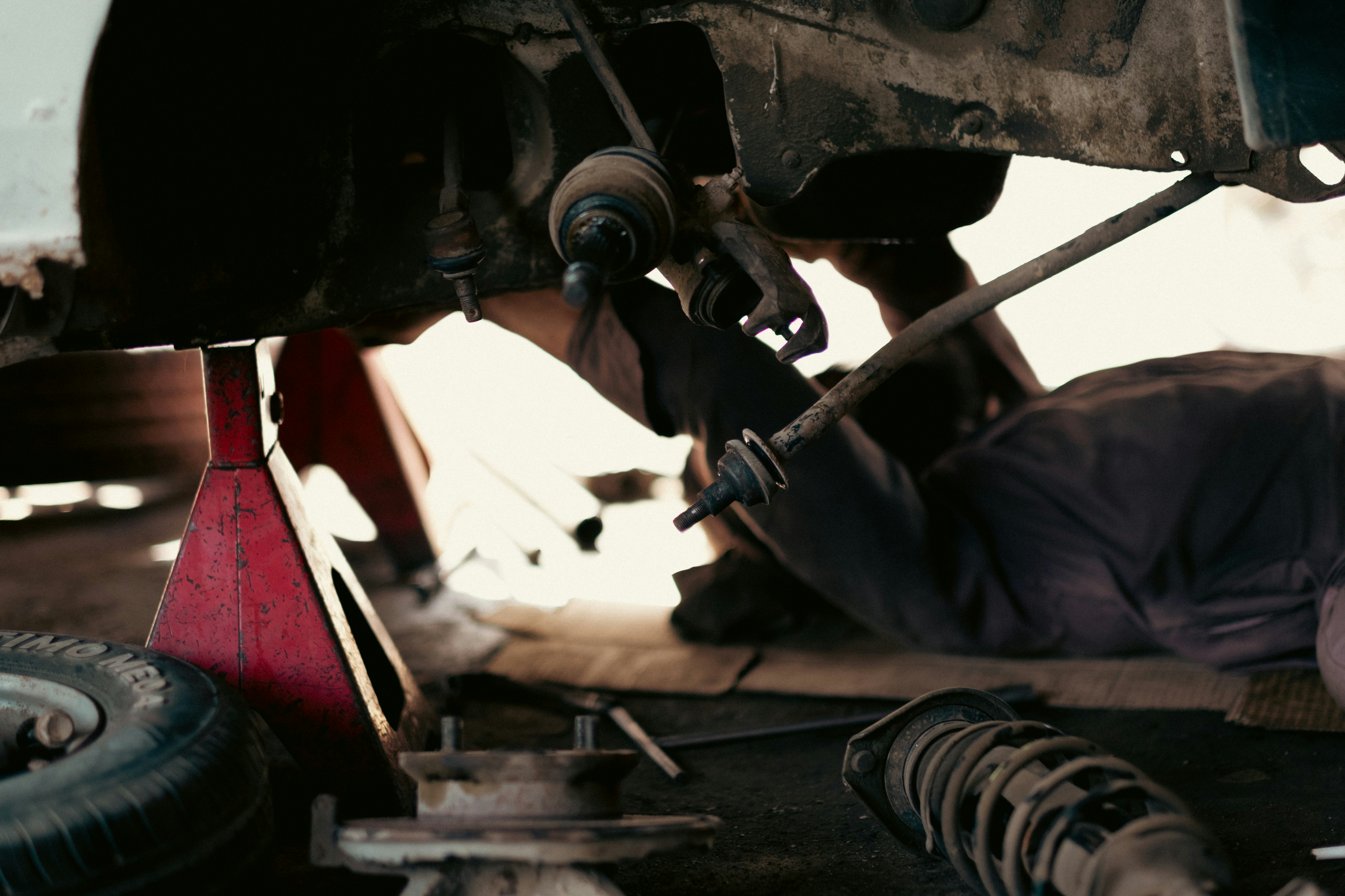 Monteur werkt onder een auto aan het onderstel